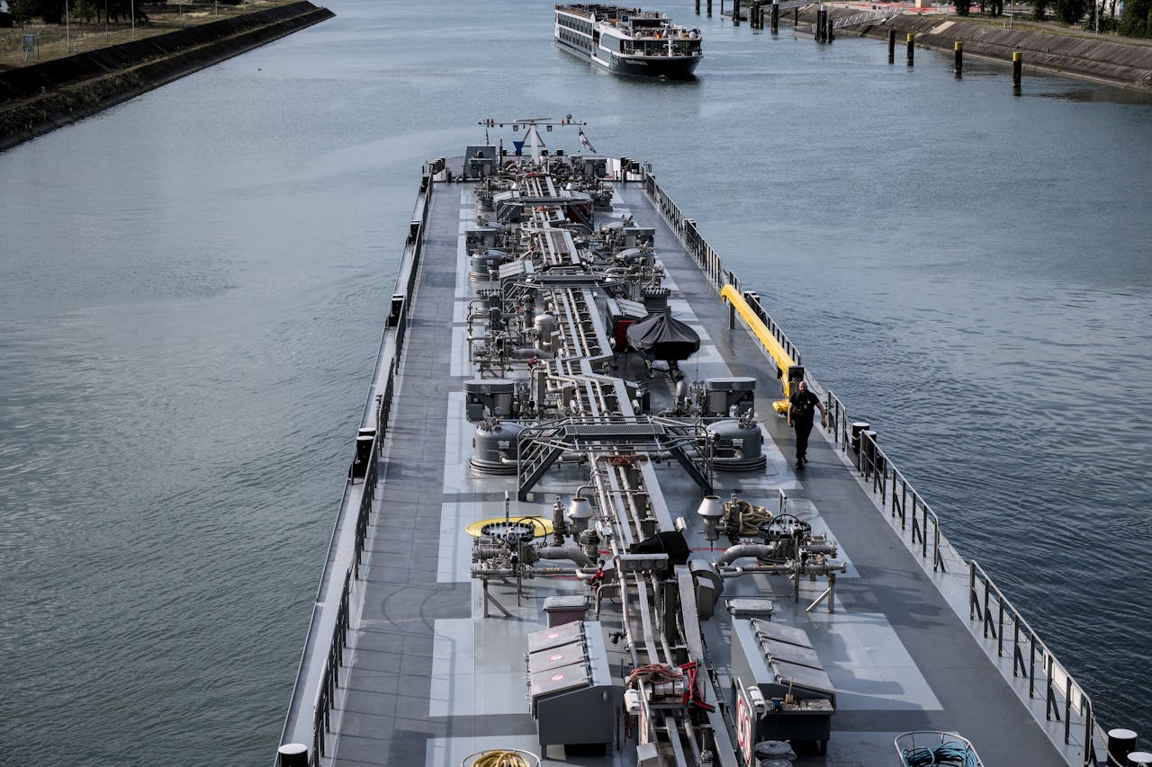 An industrial ship navigating through a canal with another vessel in the distance on a clear day.